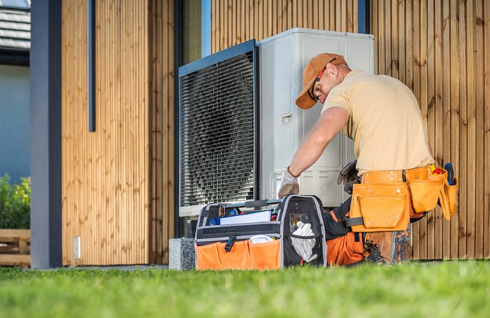 Wartung Wärmepumpe Wartung einer Wärmepumpe: Ein Installateur wartet eine Wärmepumpe an einem Einfamilienhaus.